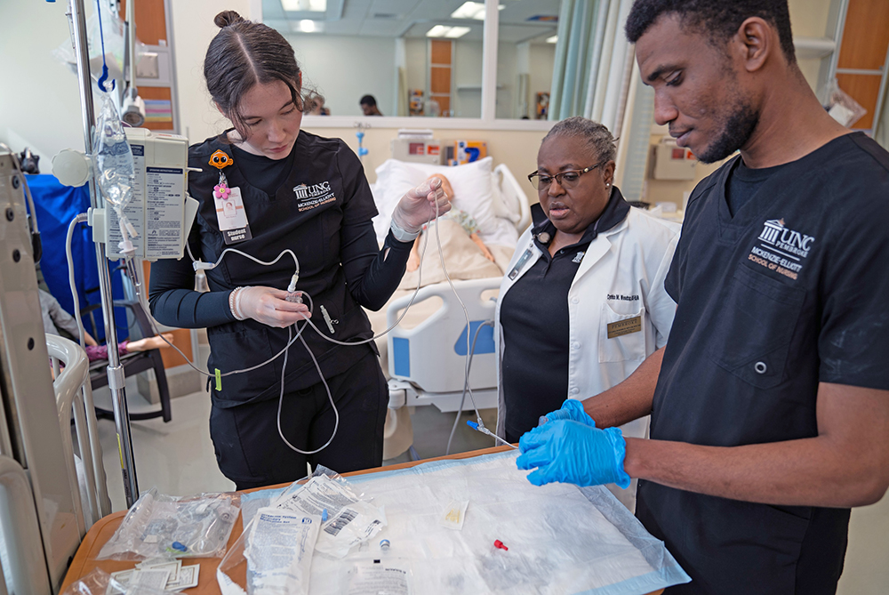 UNC Pembroke nursing emblem on sleeve of white coat while person is writing notes