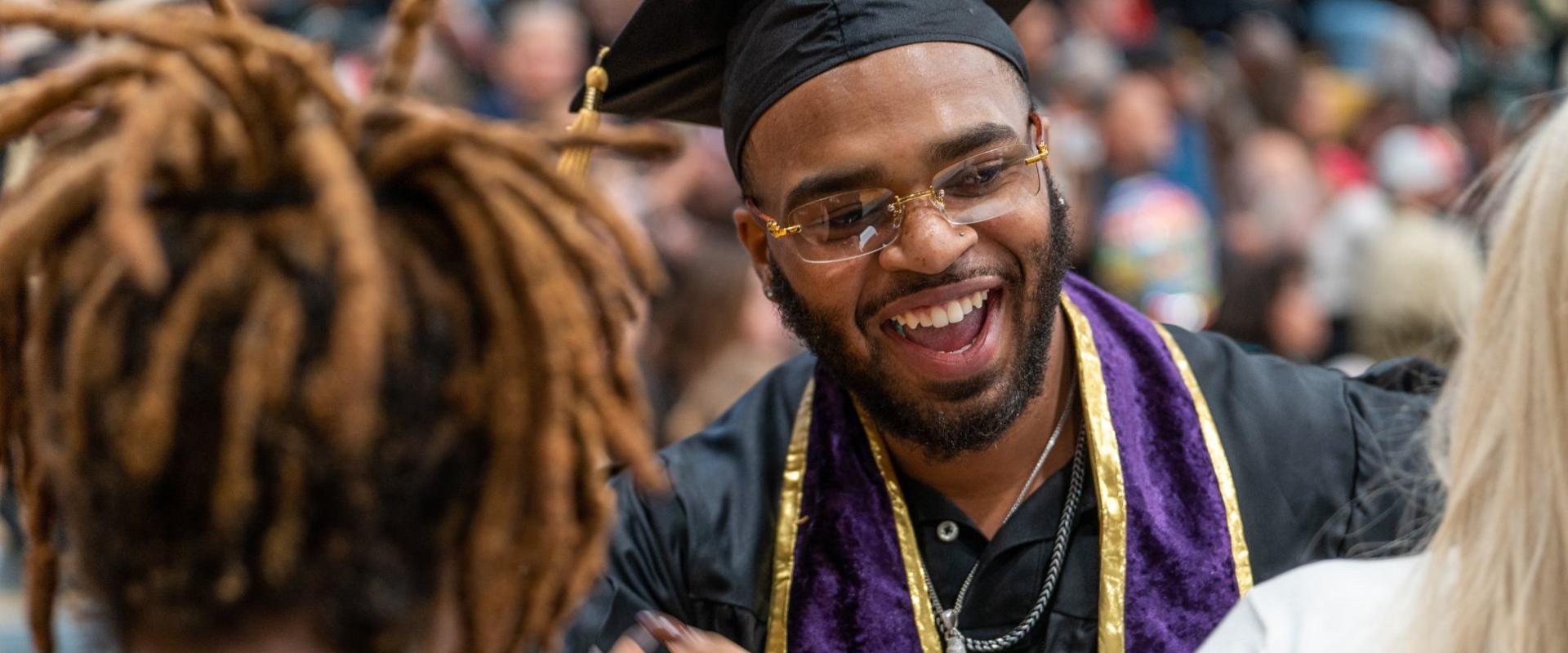 UNCP student smiles and leans in for a hug during commencement.
