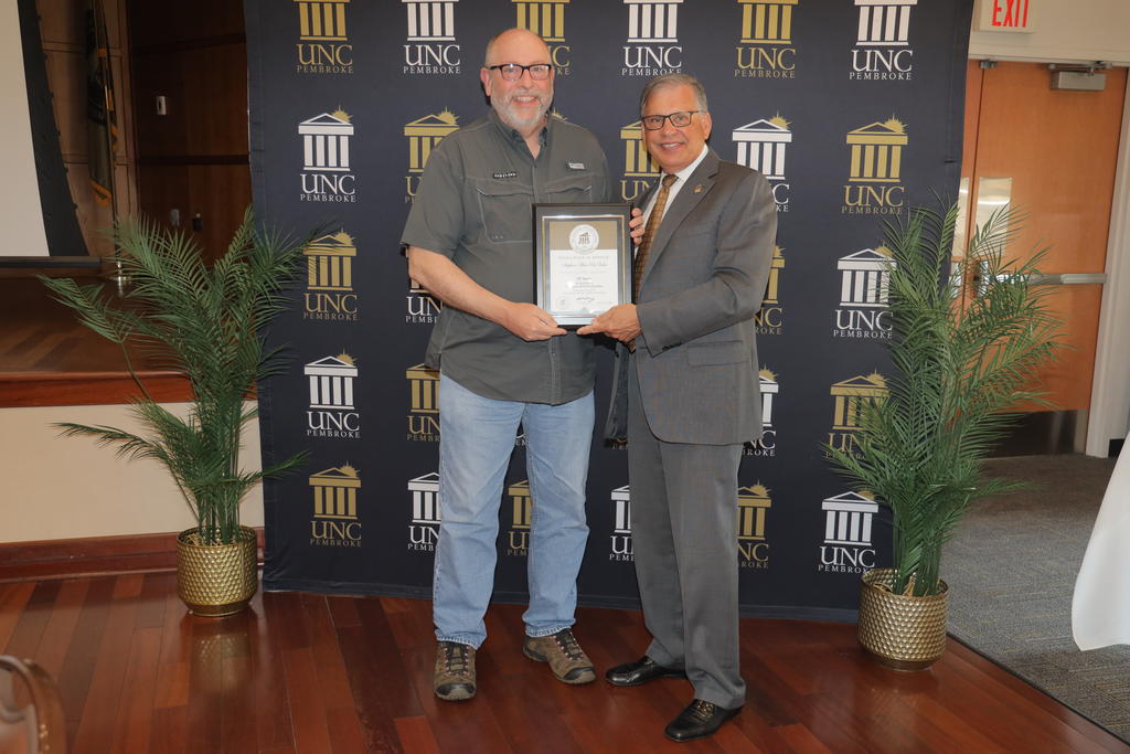 Chancellor Robin Gary Cummings presents Alan PreVatte with a service award recognizing his 25 years of service