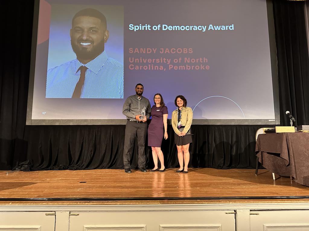 Sandy Jacobs is being presented with the Spirit of Democracy award by Cathy Copeland, director of ADP, (left) and Romy Hübler, the 2022 winner of the Spirit of Democracy award.