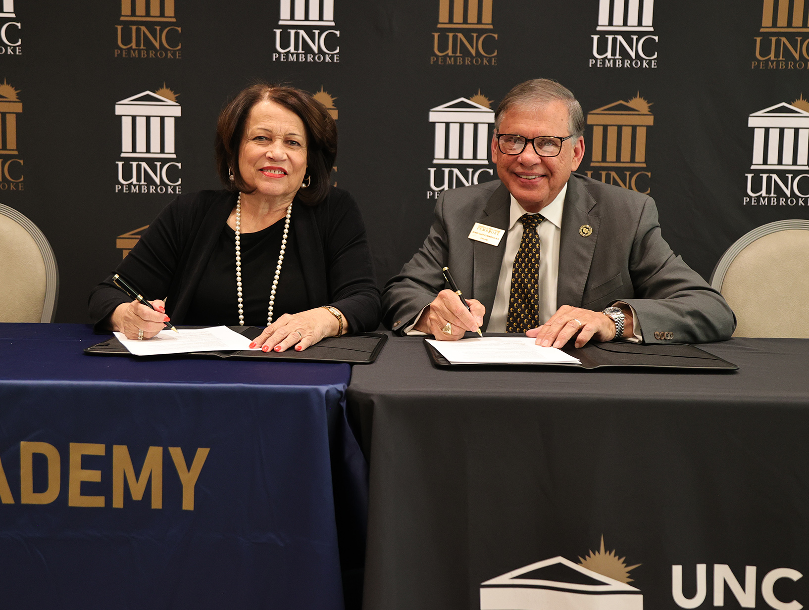 Dr. Rose Marie Lowry-Townsend, chair of Old Main STREAM Academy, and UNC Pembroke Chancellor Robin Gary Cummings sign a dual enrollment agreement.