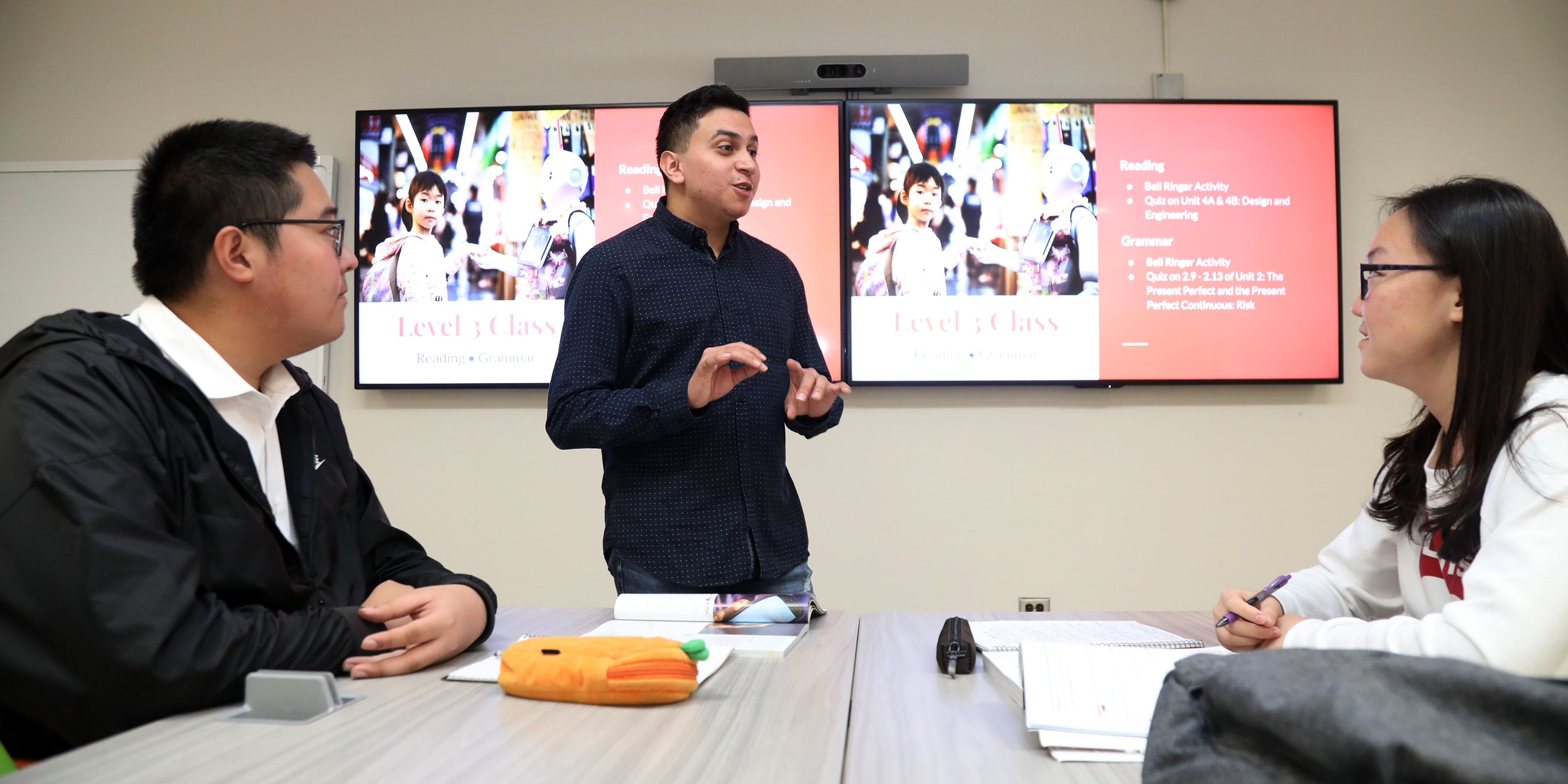 Male English teacher in the front of a high school classroom