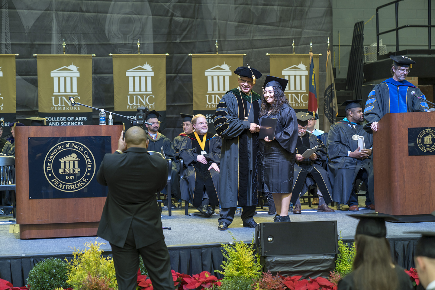 student shaking UNC Pembroke Chancellor's hand during commencement