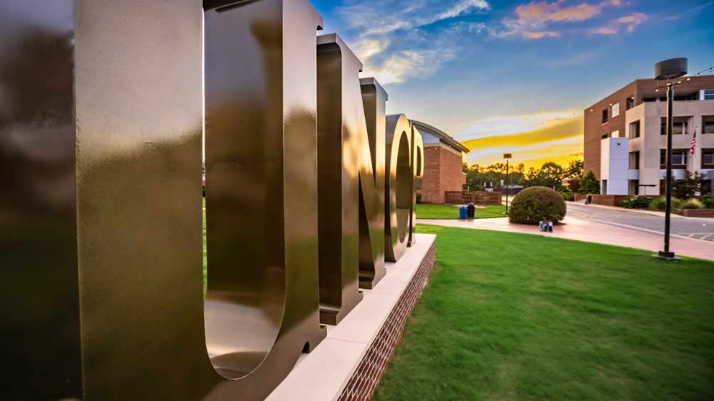 UNC Pembroke campus with UNCP letters at sunset
