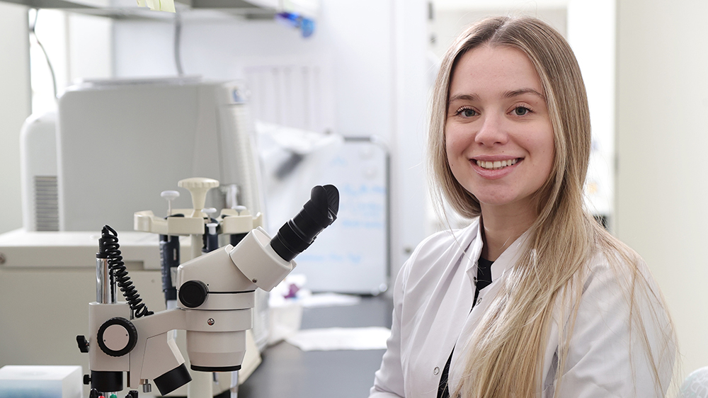  Iva Angjeleska  sitting in front of a microscope