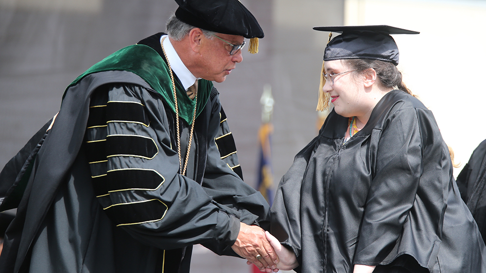Michelle Bailey shakes Chancellor Robin Gary Cummings' hand after receiving her hard-earned sociology degree at UNC Pembroke Spring Commencement on Saturday May 4, 2024