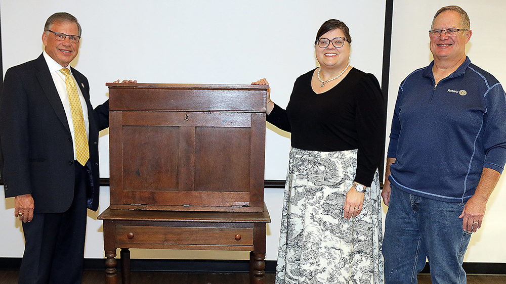 Chancellor Robin Gary Cummings, Nancy Chavis and Johnny Robertson are pictured with a writing desk