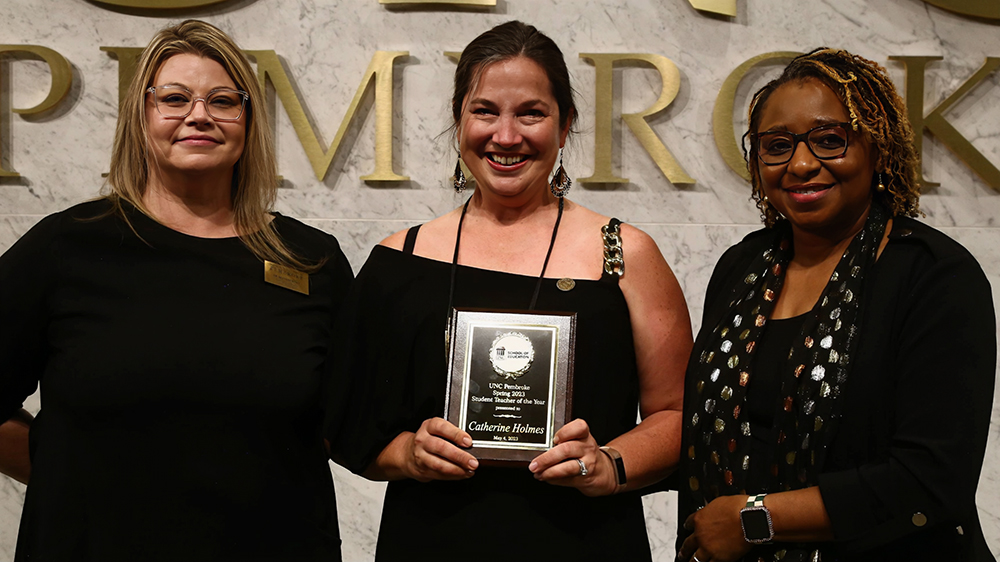 Dr. Diana Dubisky, left, and Dean Loury Floyd, right, presents Catherine Holmes with the 2023 Student Teacher of the Year Award