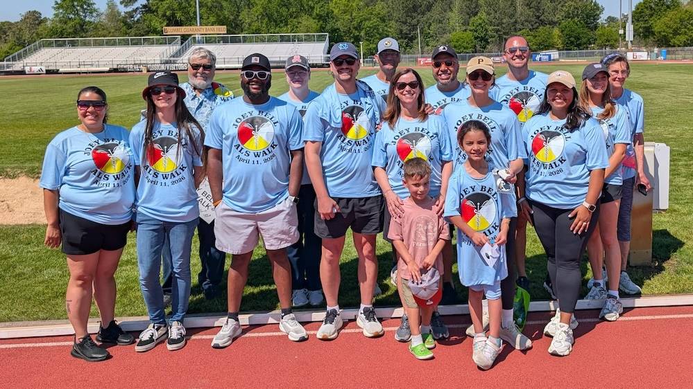 UNCP Leadership, Learning and Community staff and members of the Bell family pose together in matching Joey Bell ALS Walk T-shirts on the track at Grace P. Johnson Stadium at the inaugural Joey Bell ALS Walk on April 11, 2026.