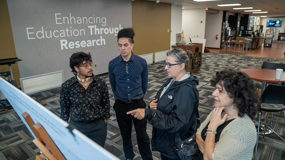 REACH Fellow Ahe Oxouzidis (second from left) discusses his ongoing 