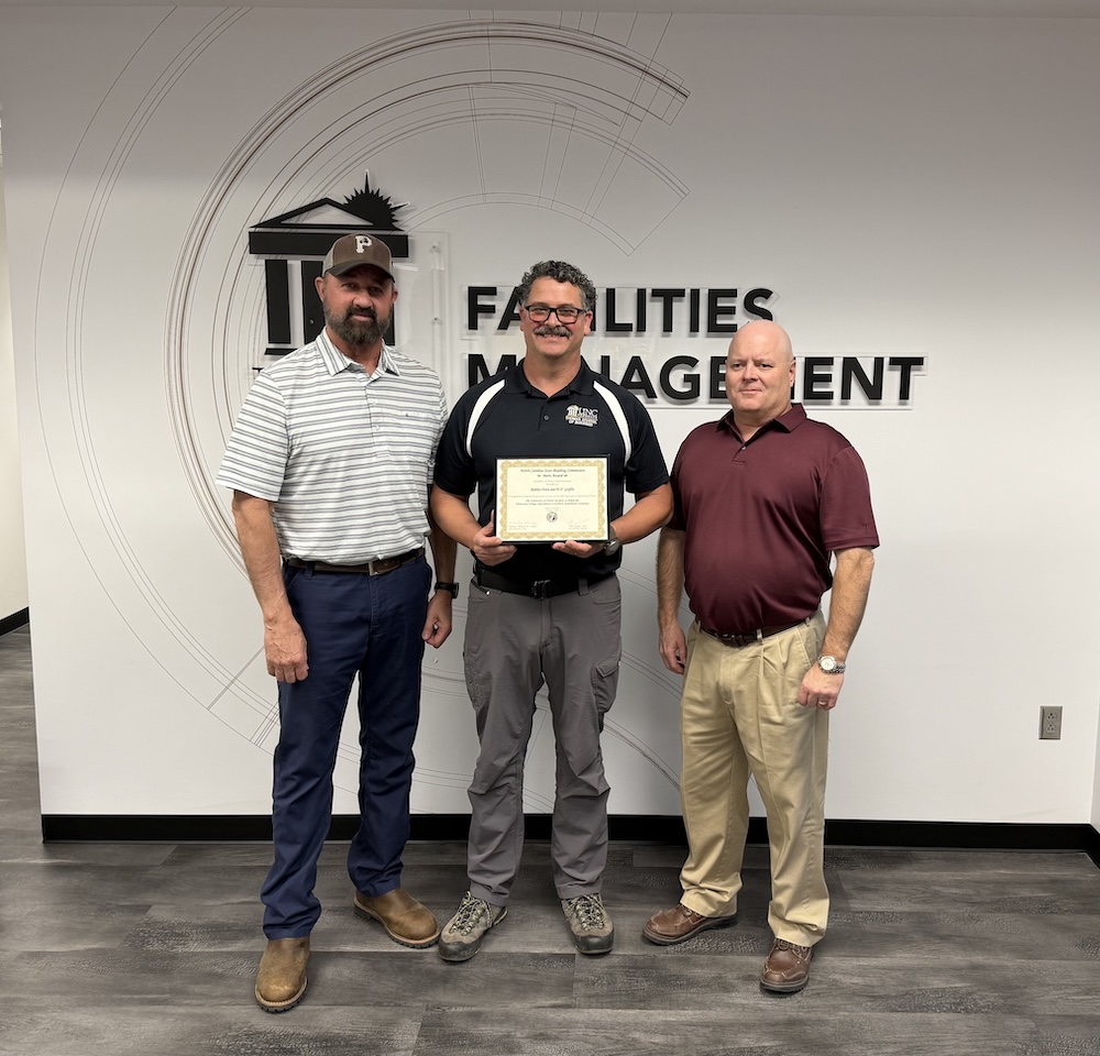 Victor Deese, assistant vice chancellor for Facilities, Kevin Witmore, senior project manager, and Michael Bullard, director of Environmental Health and Safety, pose together at the State Building Commission Merit Award luncheon.