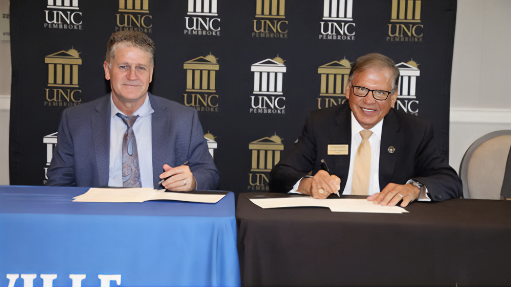Blair Fisher (left) Head of School at Fayetteville Academy and Chancellor Robin Gary Cummings sign an agreement establishing the UNCP and Fayetteville Academy Joint Enrollment Partnership