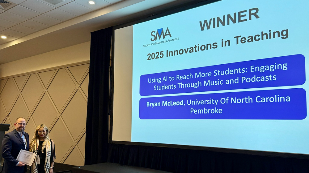 Dr. Bryan McLeod in front of a large screen