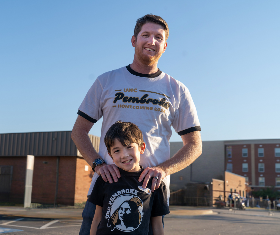 UNCP Director of Development Branan Denard stands with his son on the University of North Carolina Pembroke campus.