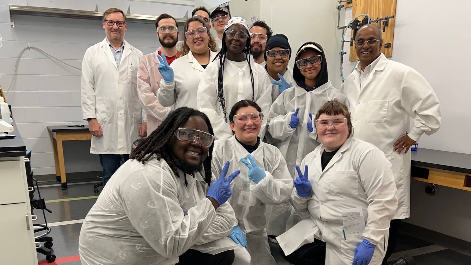 group of students in lab coats posing for a photo