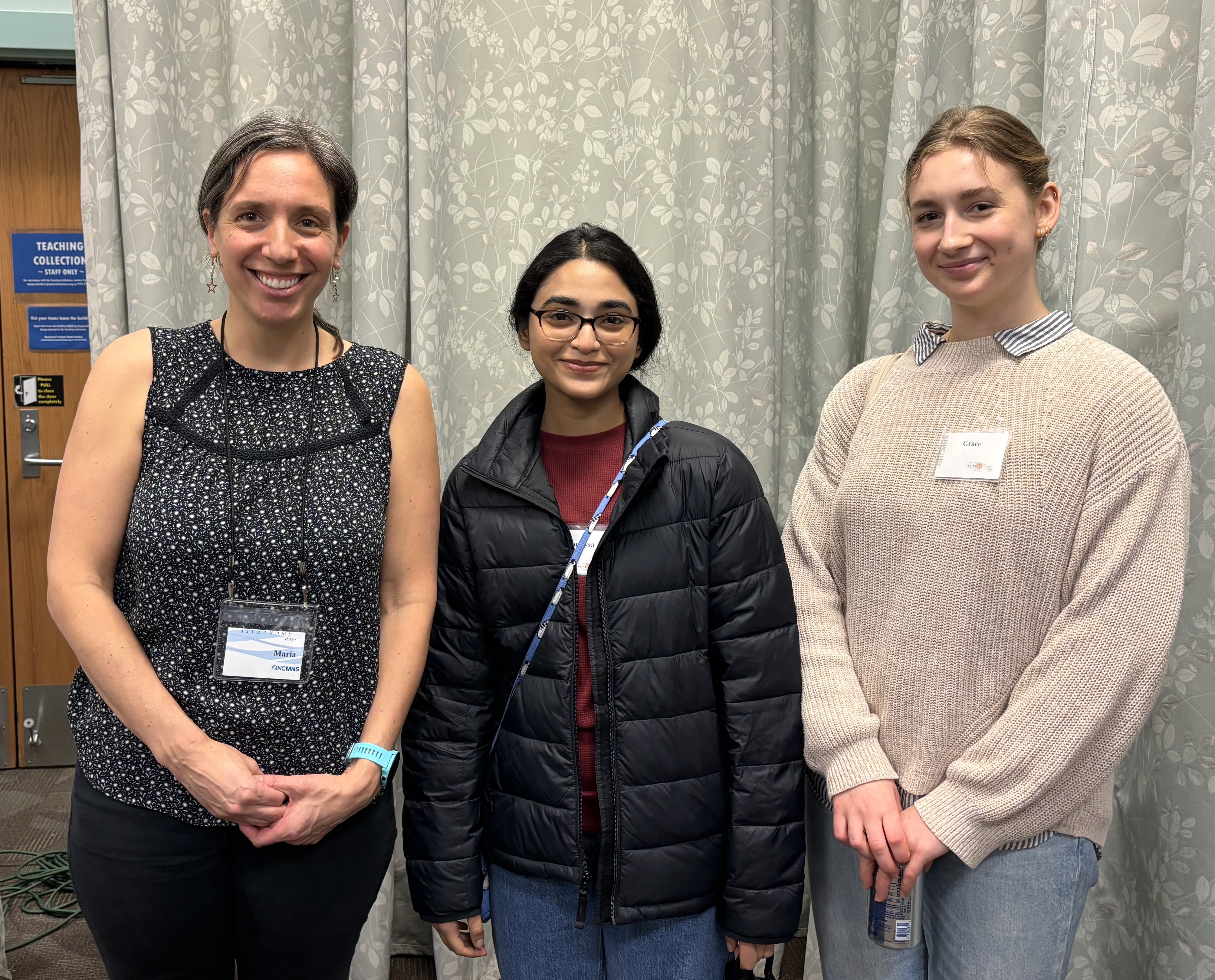 Three college students pose and smile at the event