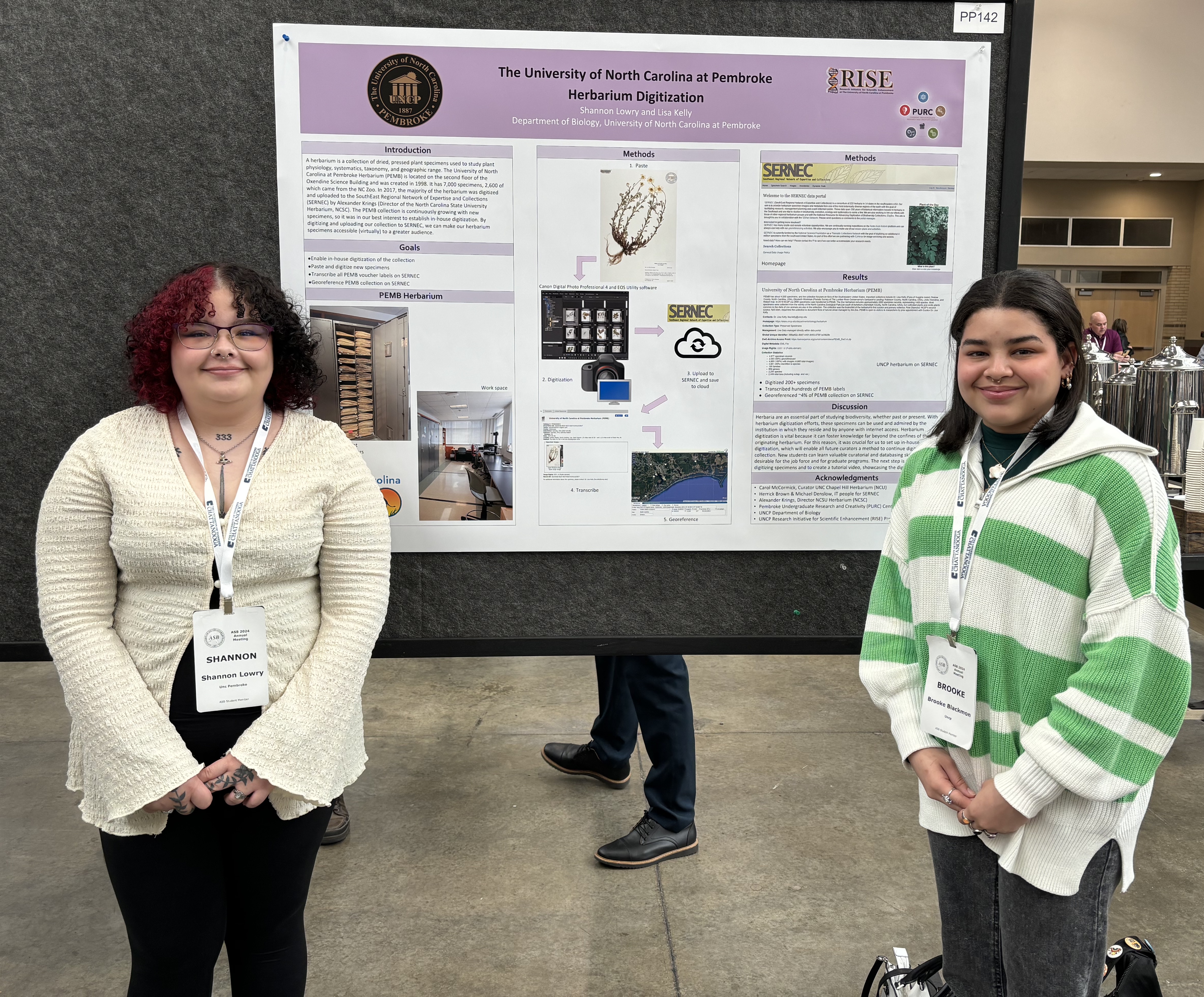 Shannon Lowry (left) and Brooke Blackmon (right) standing with a poster presentation at ASB Conference.