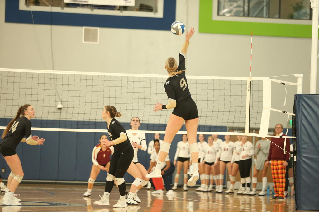 Volleyball player jumps into the air to spike the ball.