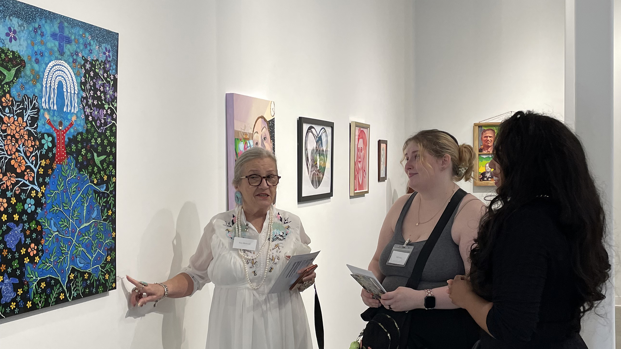 Discussion between 3 people at the 2025 UNCP Art Alumni Biennial Juried Exhibition
