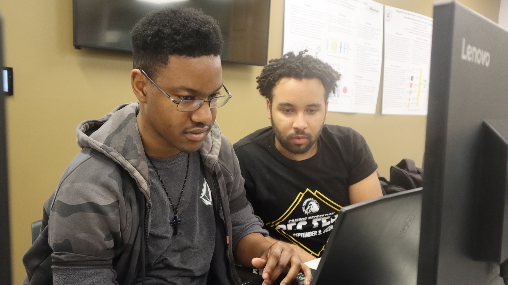 two male students on laptop in class