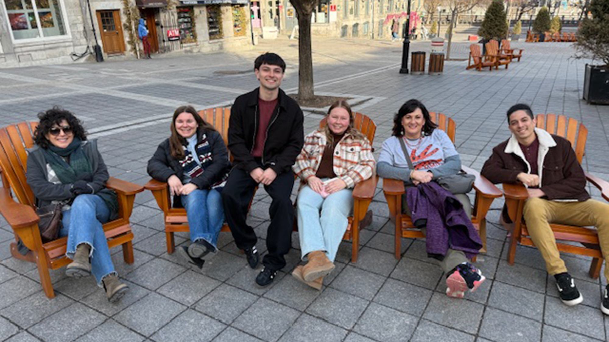 REACH students sitting in chairs in a square in Montreal