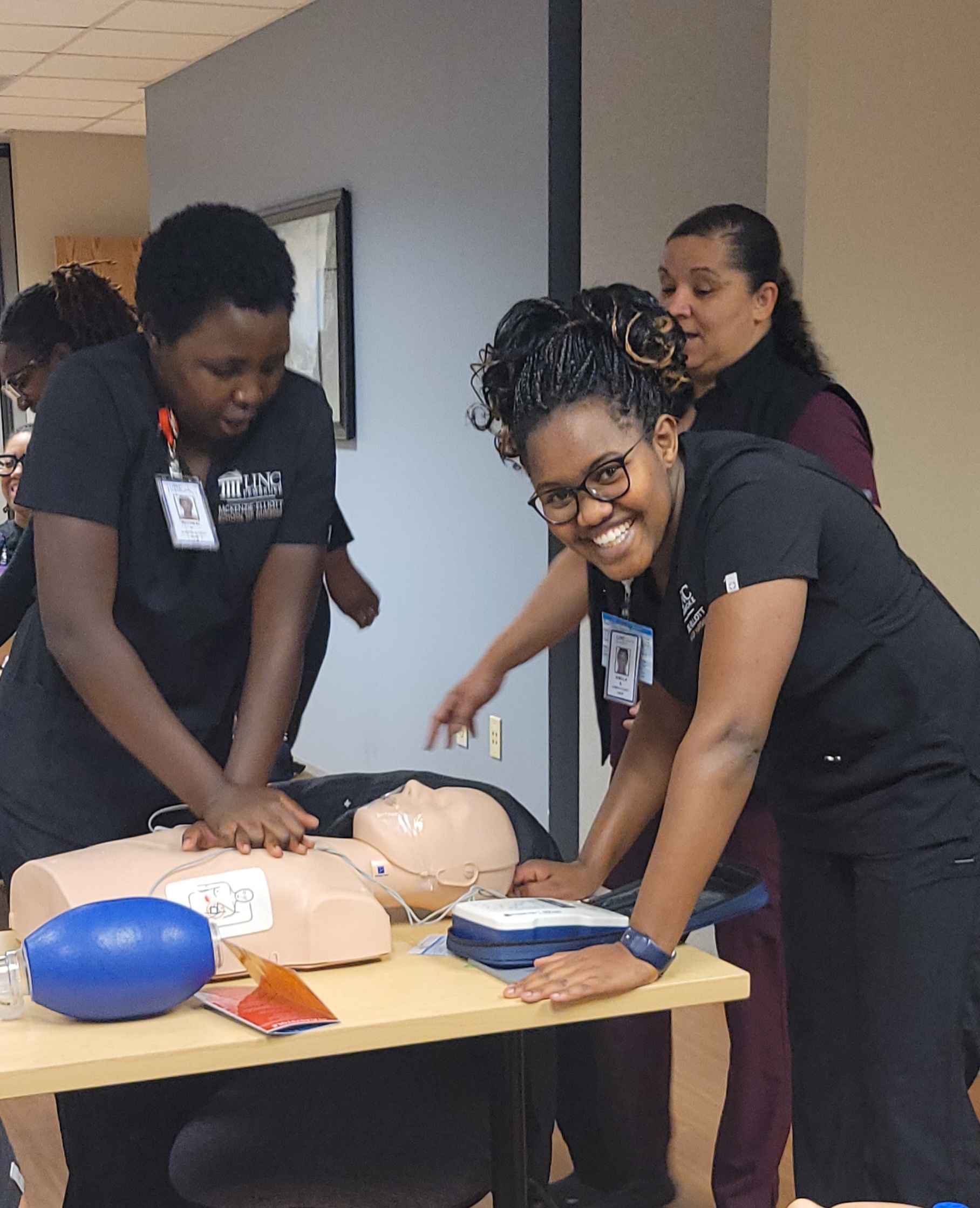 UNCP nursing students working with a healthcare mannequin.