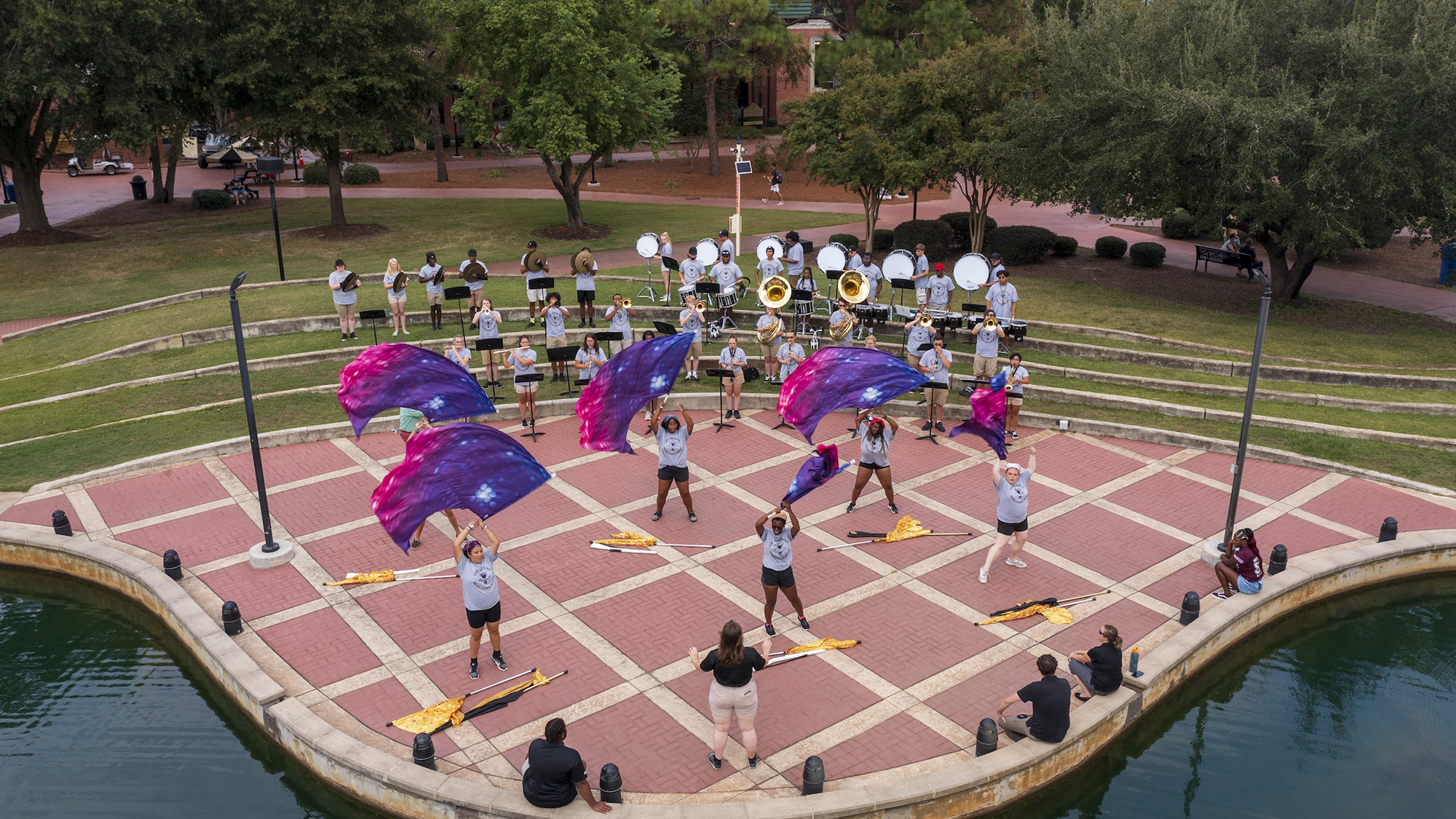 aerial drone picture of marching band and colorguard performing in the quad