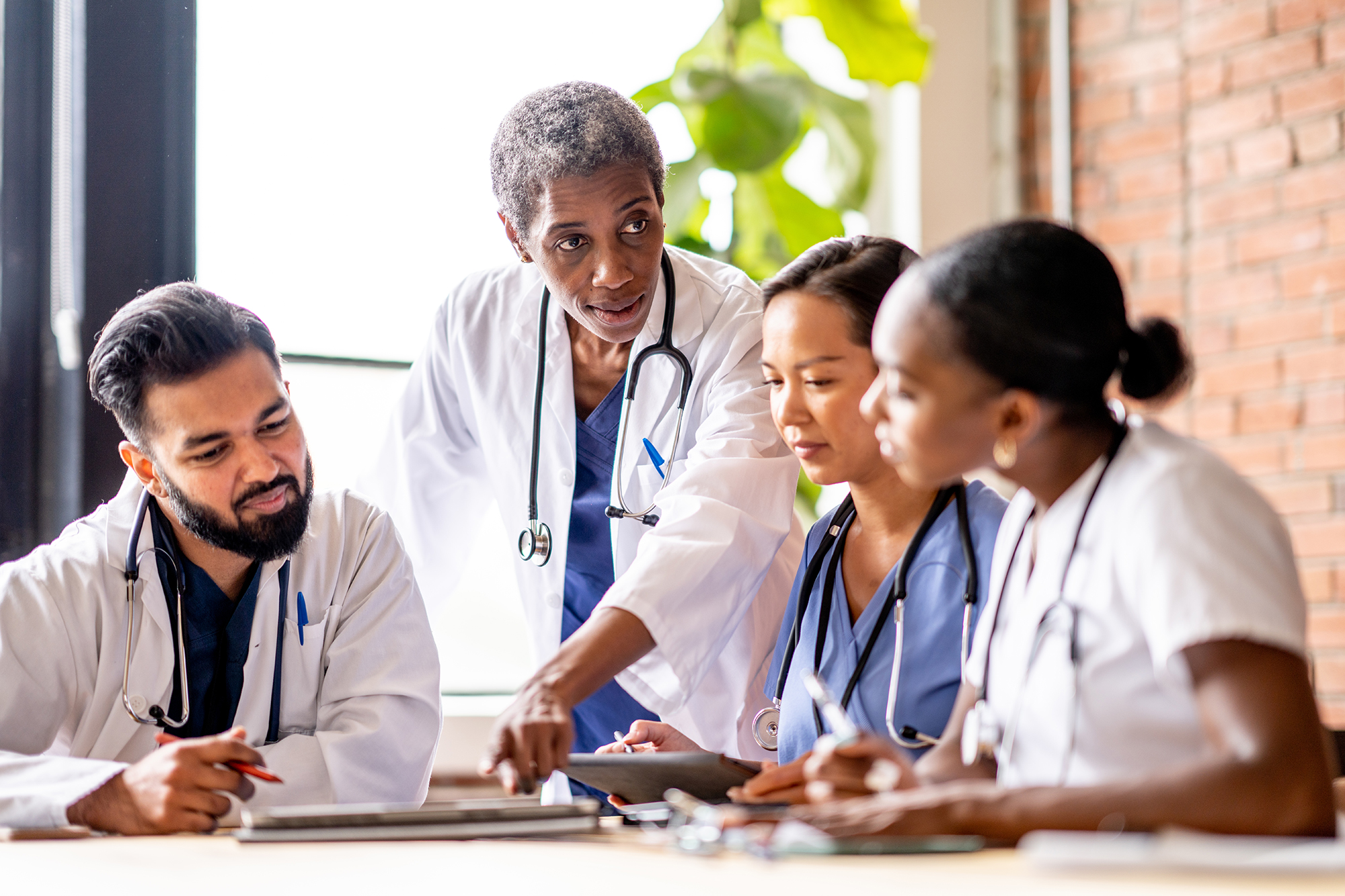 group of male and female nurses discussing charts