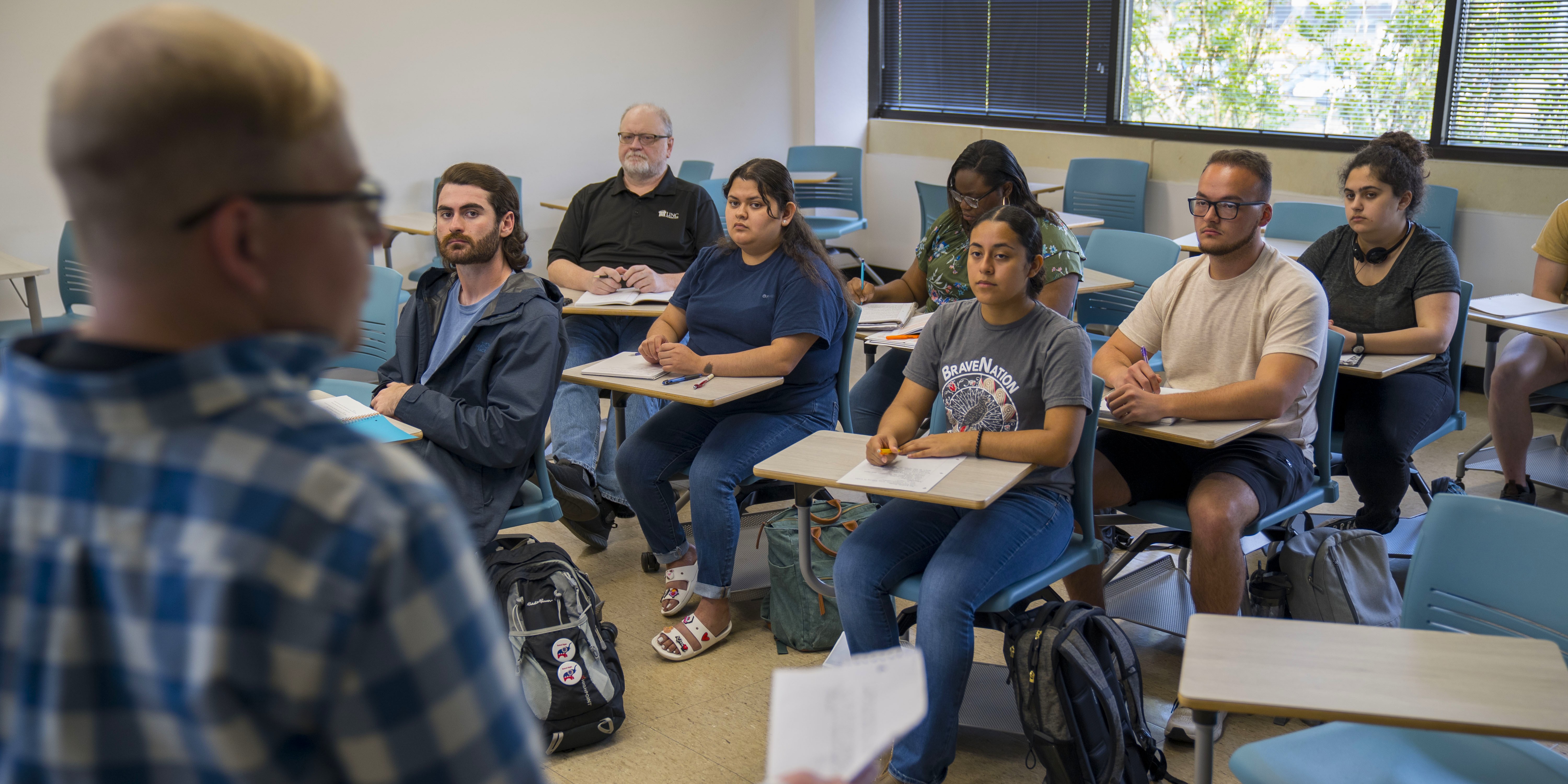 Over the shoulder view of a history student givine a presentation to calssmates at UNC Pembroke.