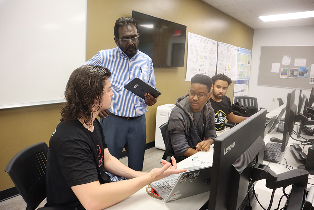 faculty member works with students in cyber UNCP classroom