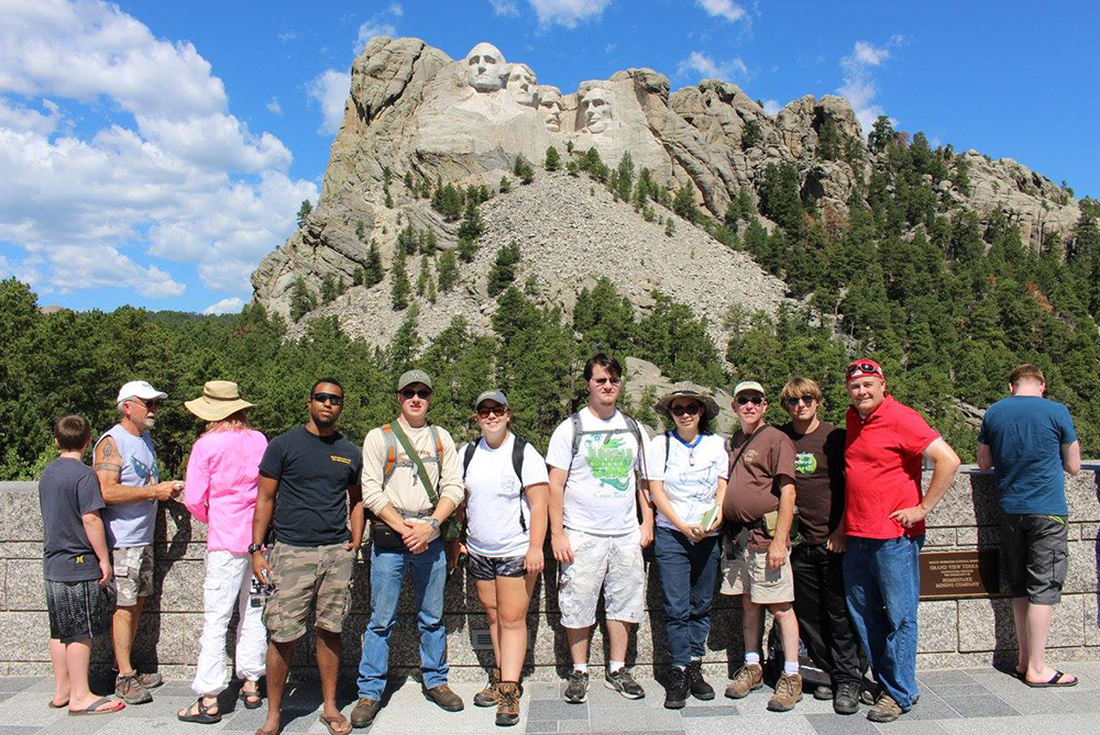 UNC Pembroke students posing in front of Mnt. Rushmore during a field trip.