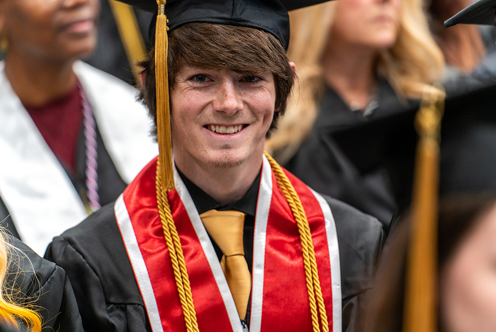 male UNCP graduate in cap and gown