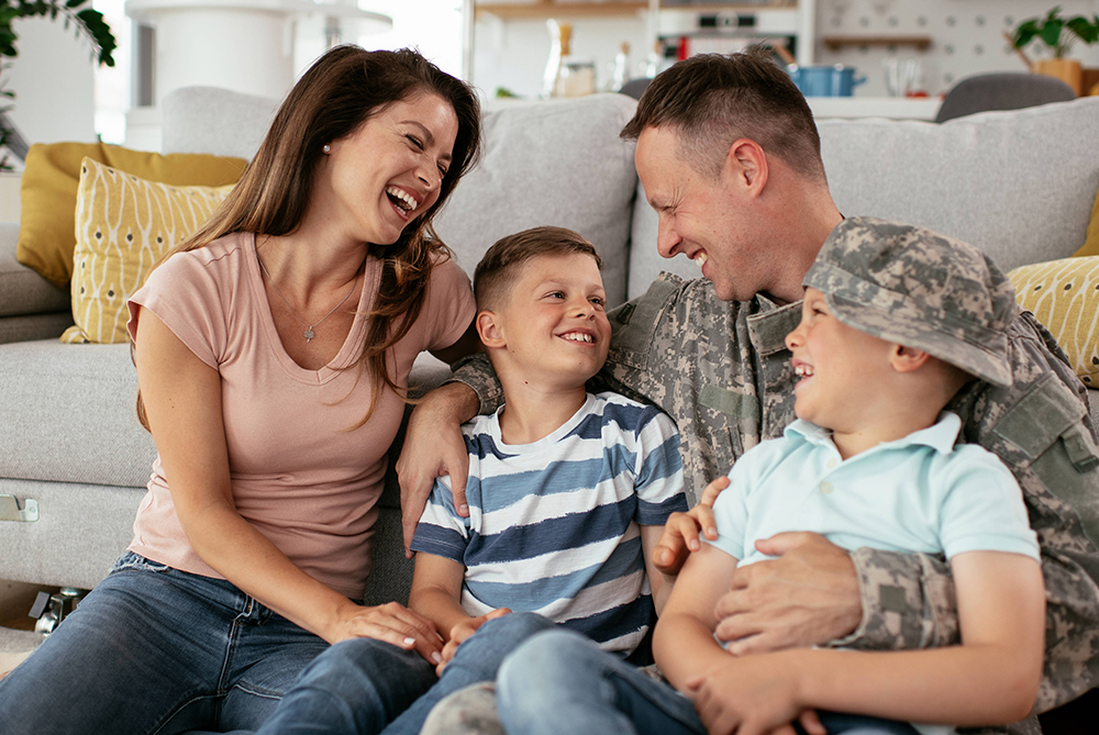 military family sitting on the floor laughing