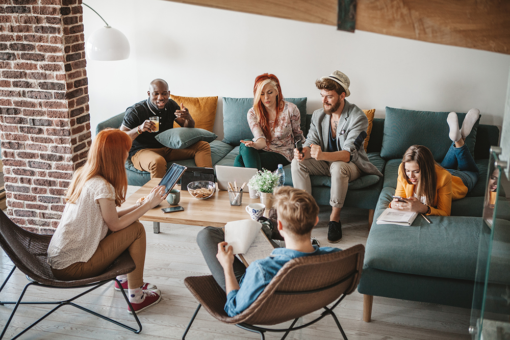group of college students sitting in a room laughing