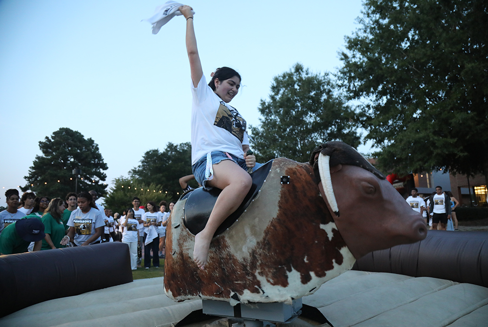 UNCP student riding the mechanical bull at FLIGHT