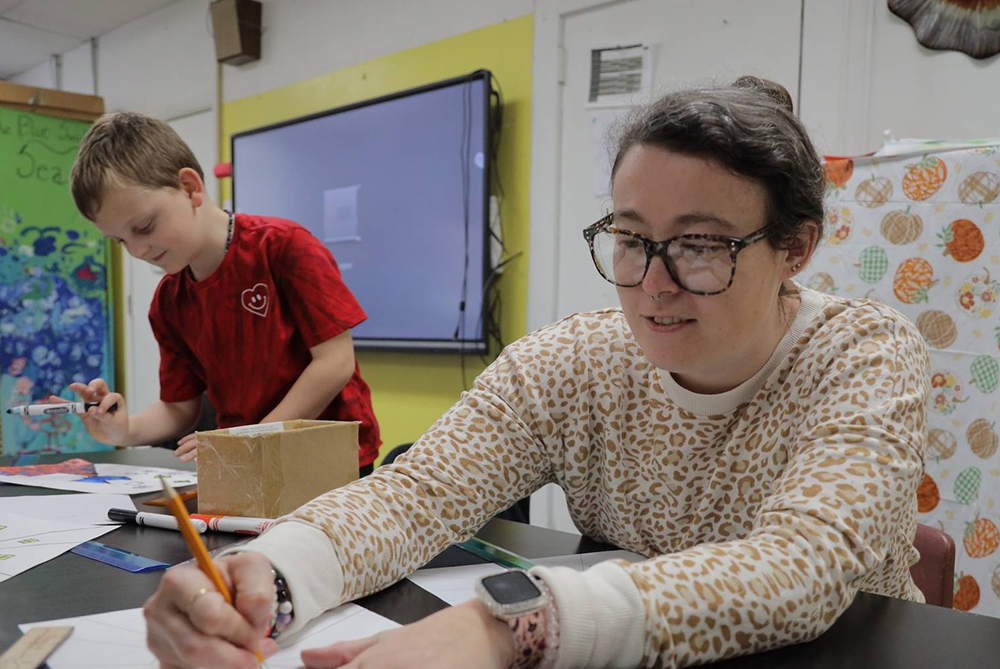 Student teacher working with students in an elementary school classroom