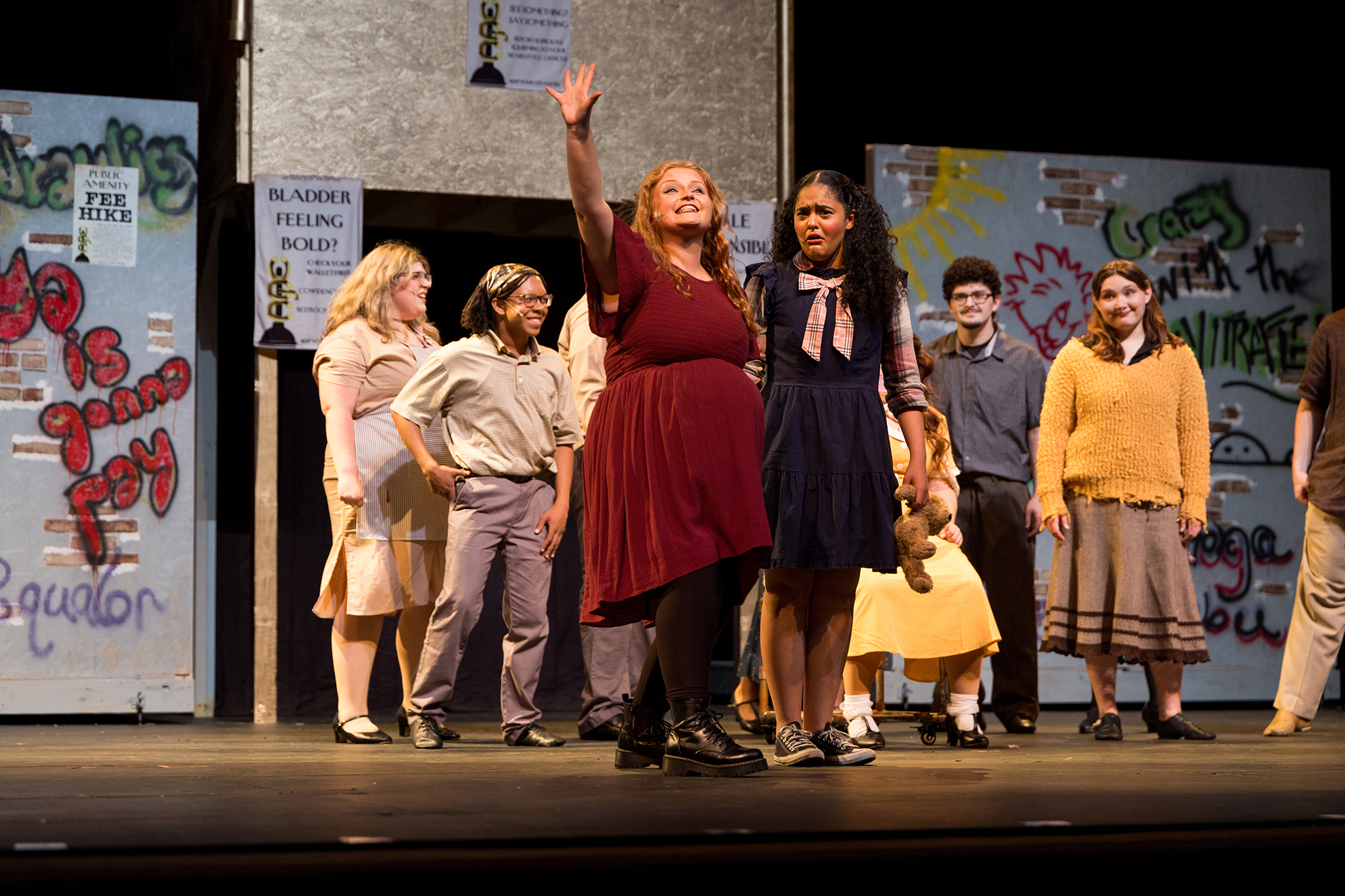 Young performers in colorful costumes act out a royal scene on stage during a theatrical production, showcasing student creativity and engagement in UNC Pembroke's theatre program.