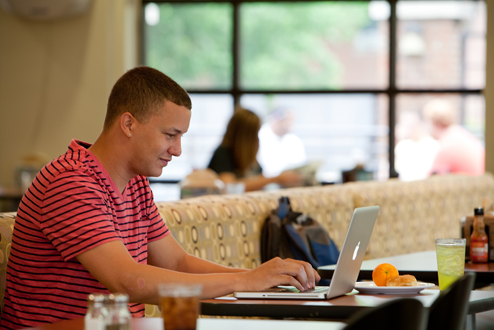 Student in Dining Hall at laptop