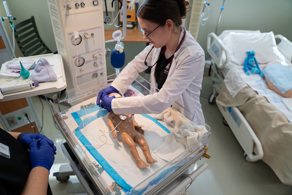 A nursing student works in the simulation lab