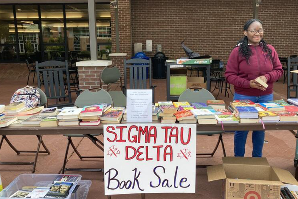 Young student at a the Sigma Tau Delta book sale table