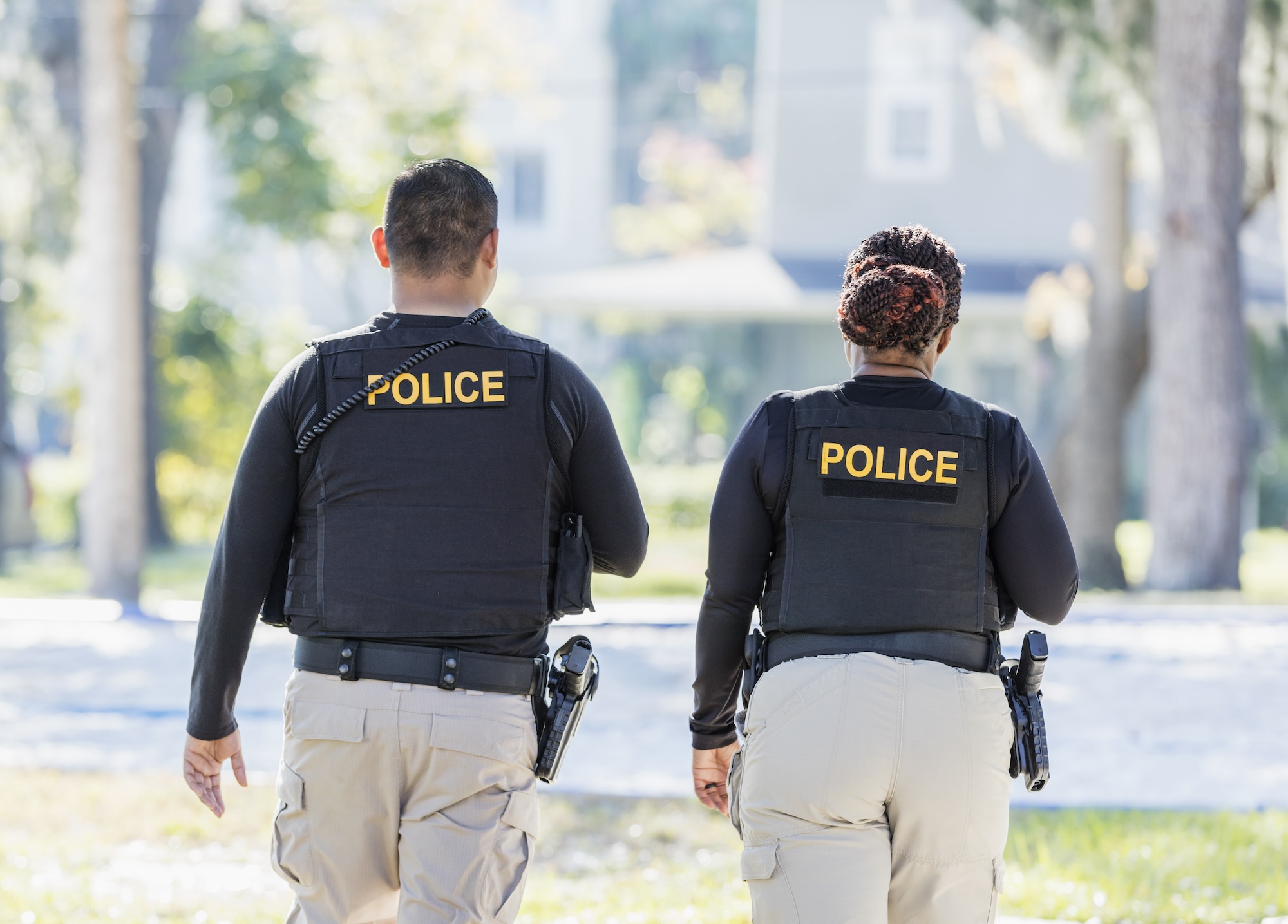 Two law enforcement officers viewed from behind in uniform, representing career paths in law enforcement for Criminal Justice graduates.