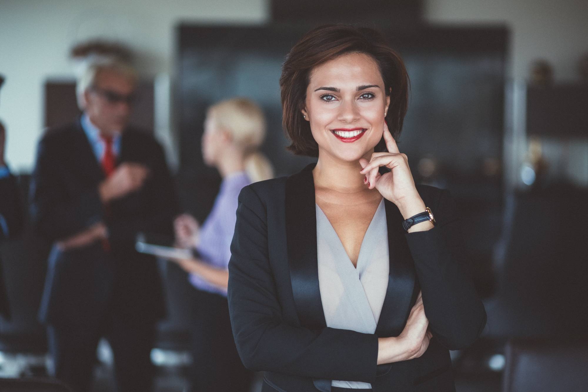 Business woman standing with people talking in the back