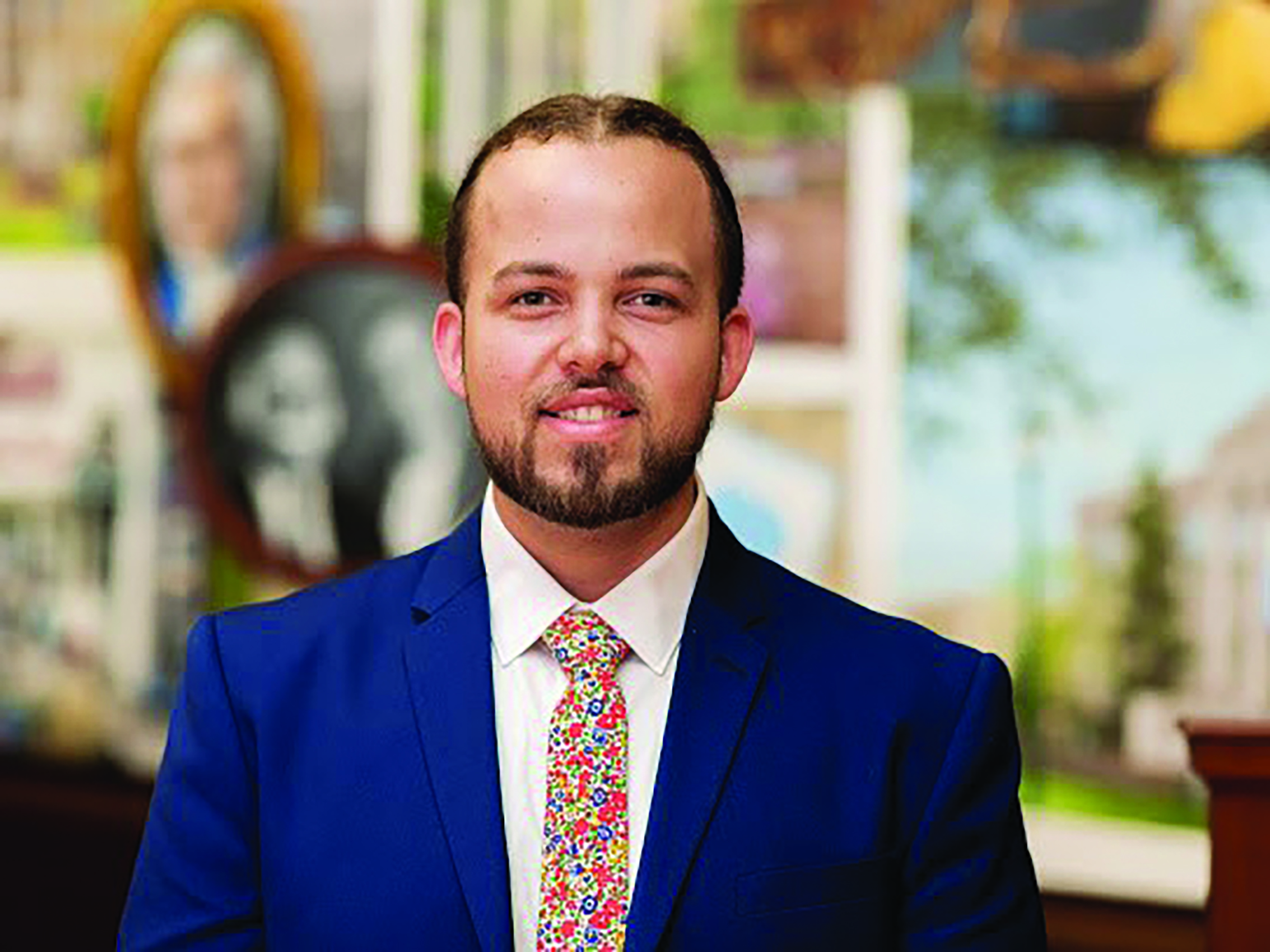 Professional headshot of Harley Locklear, Native American male in a blue suit and white shirt.