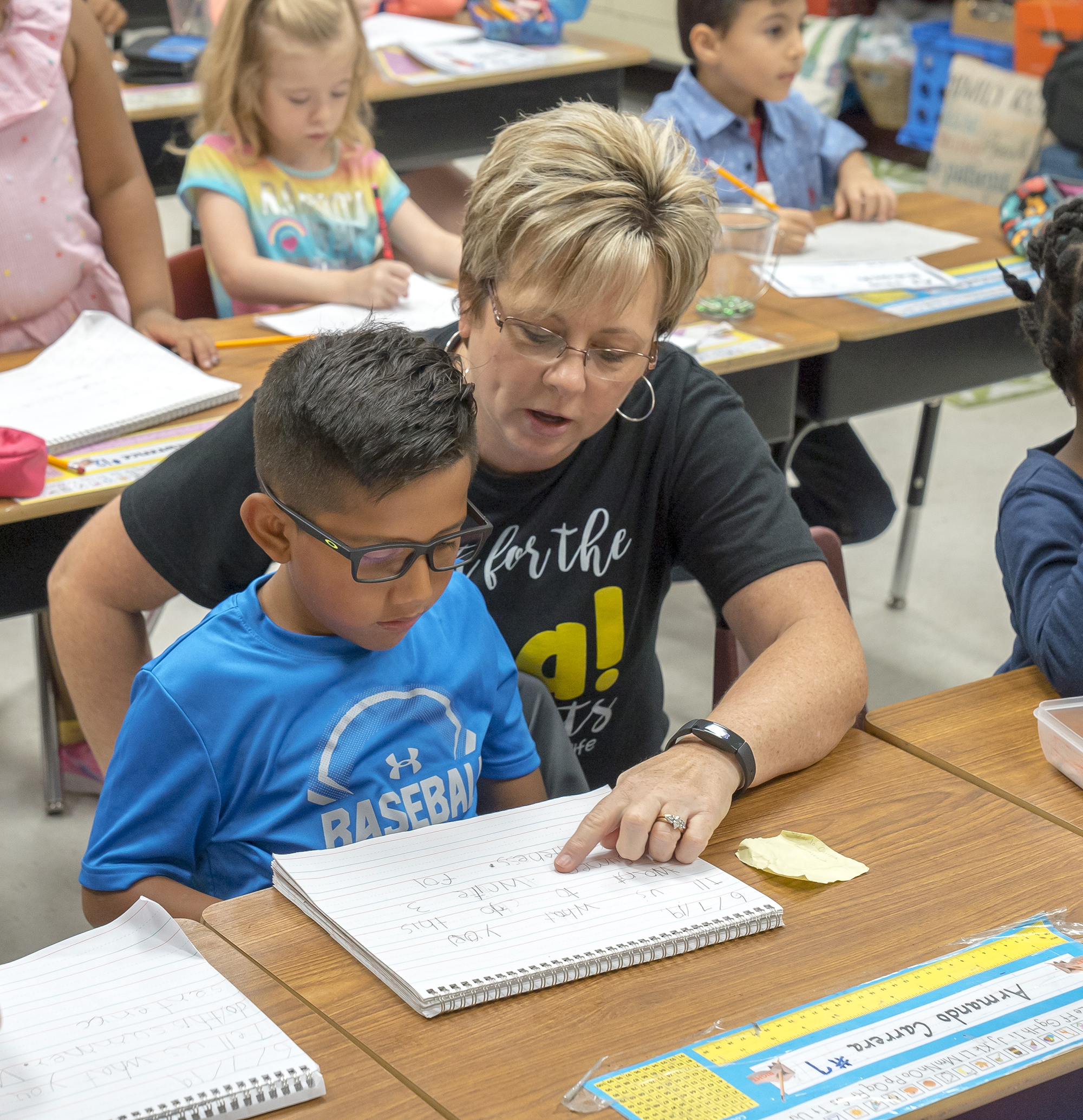 teacher at a table with small young male student
