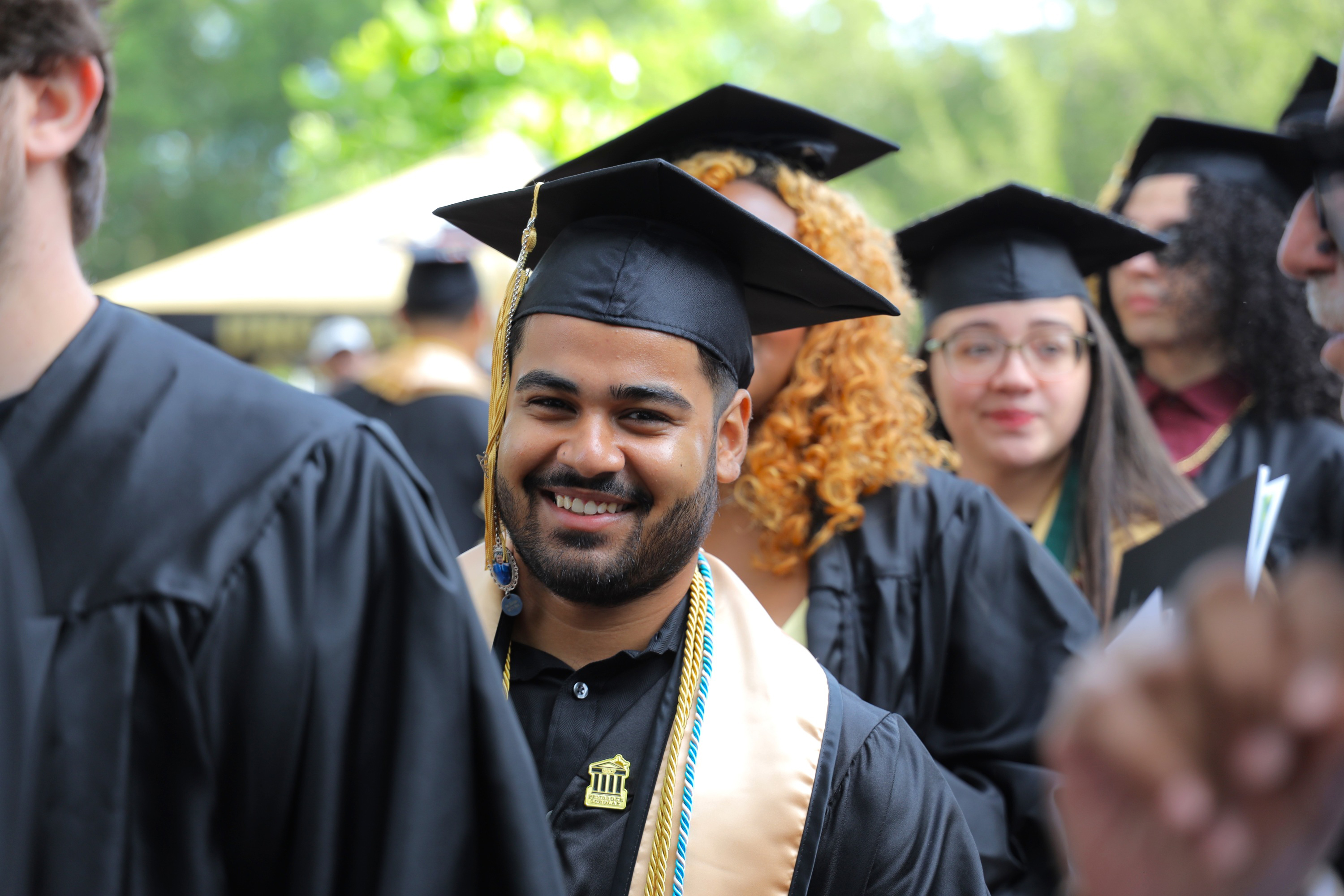 UNCP Computer Science student Harry Lamichhane stands in line at commencement in cap and gown, representing graduate success in the Computer Science program.