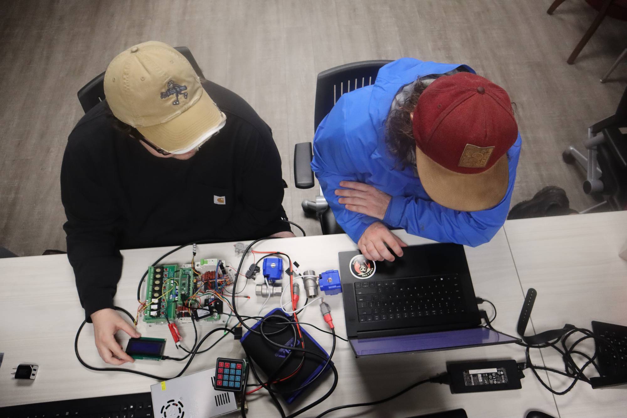 two male students with laptop and computer equipment in cybersecurity class at UNCP