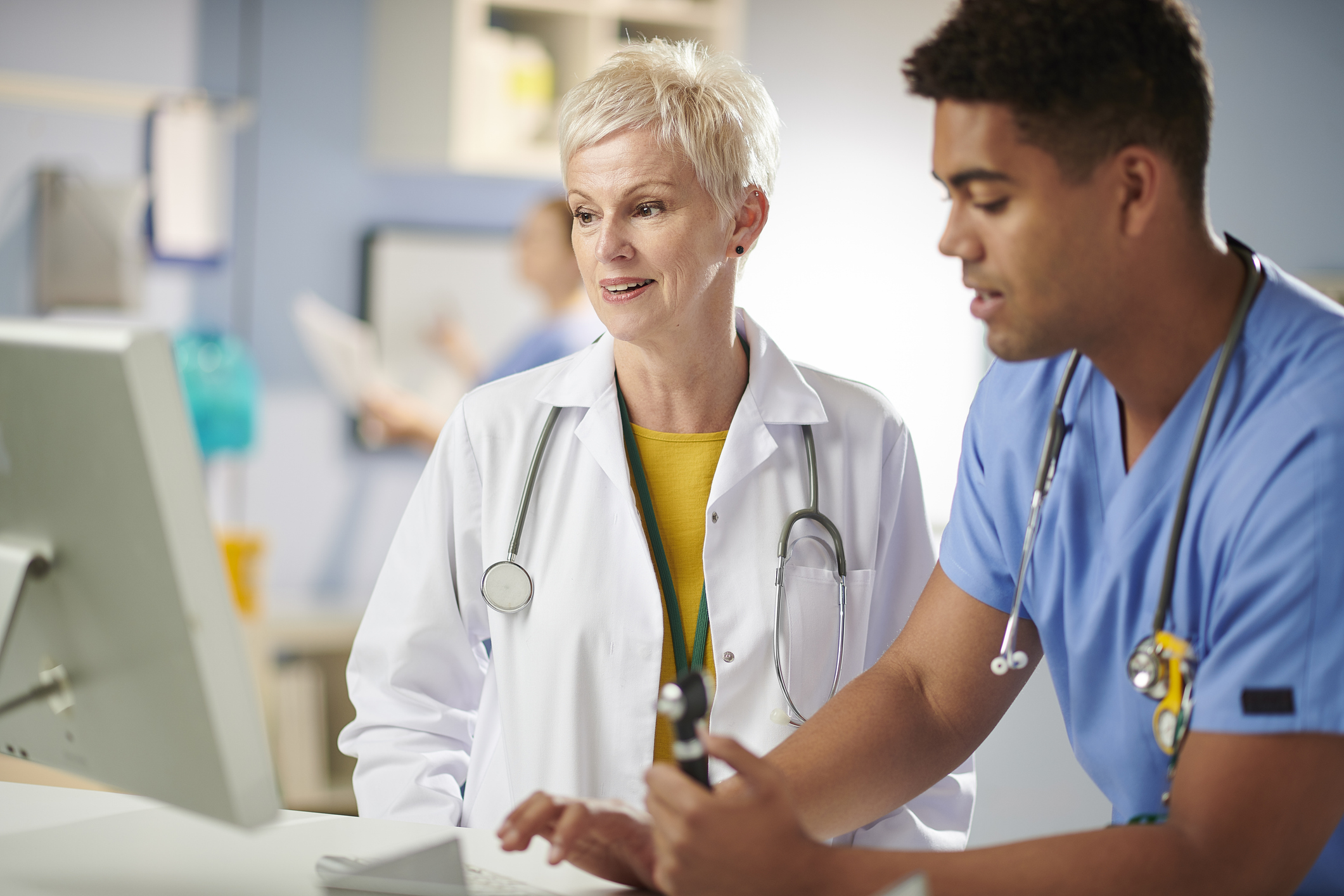 medical trainee and doctor on computer