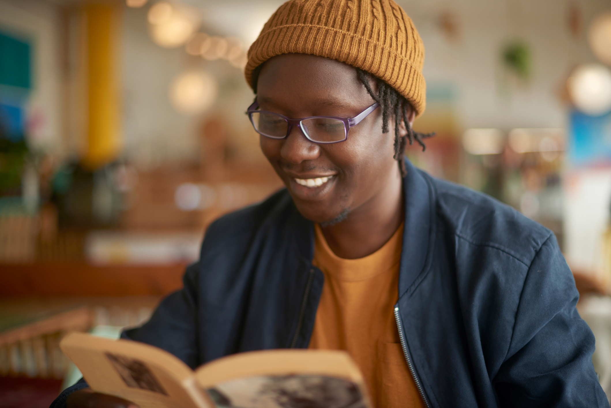 student in coffee shop reading book