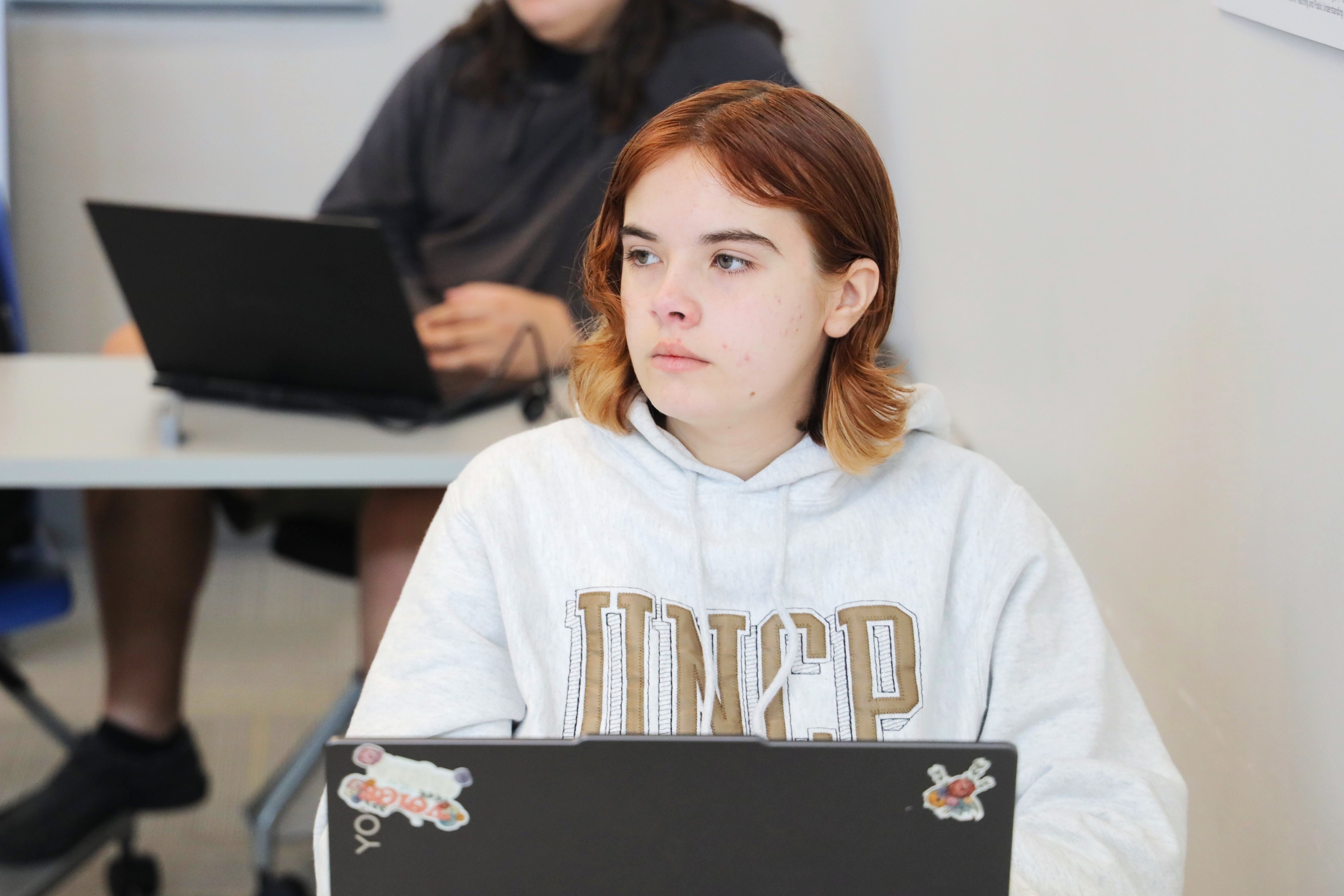 female student wearing UNCP sweatshirt in a class