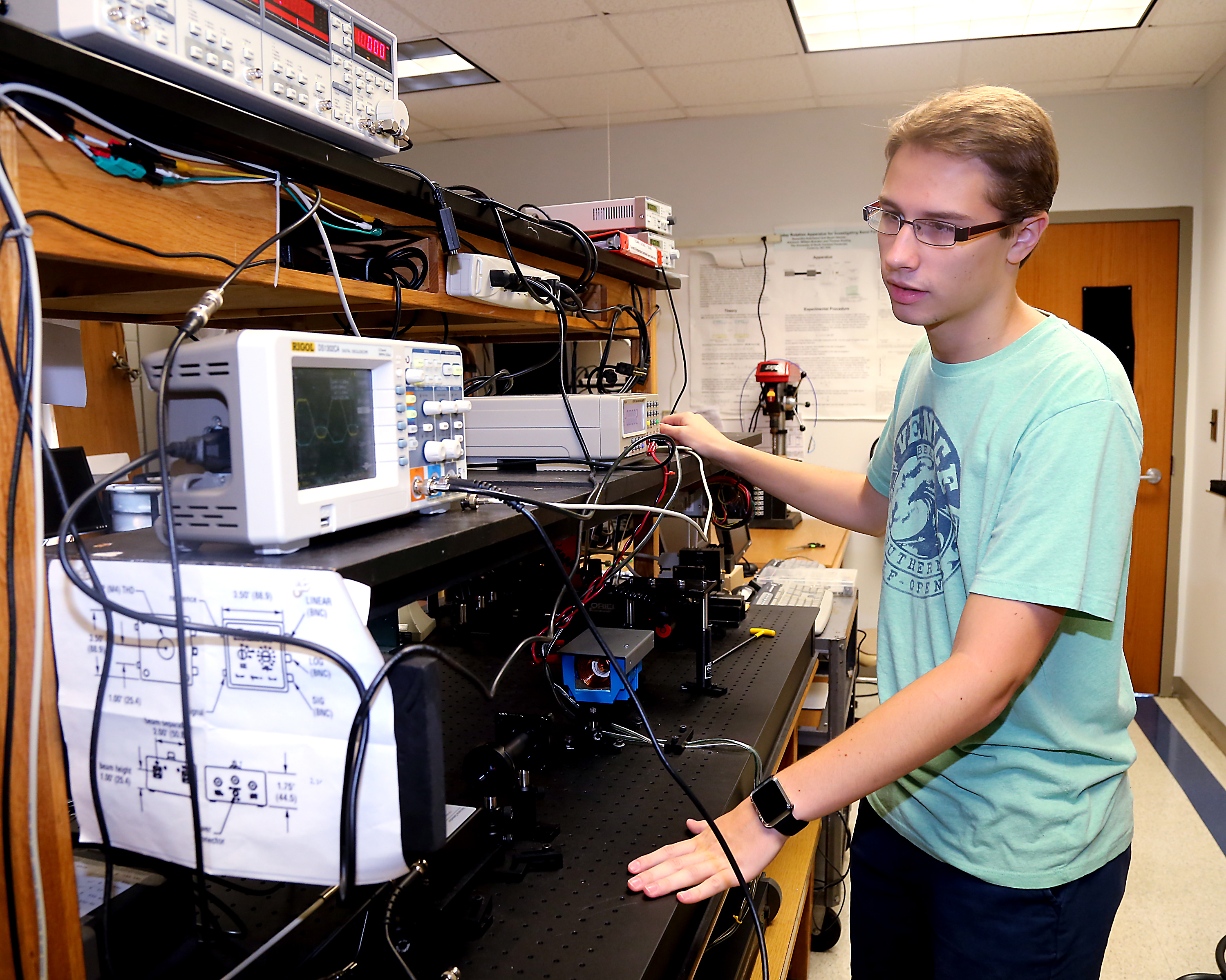 male student works with wires and science equipment in the UNCP physics lab